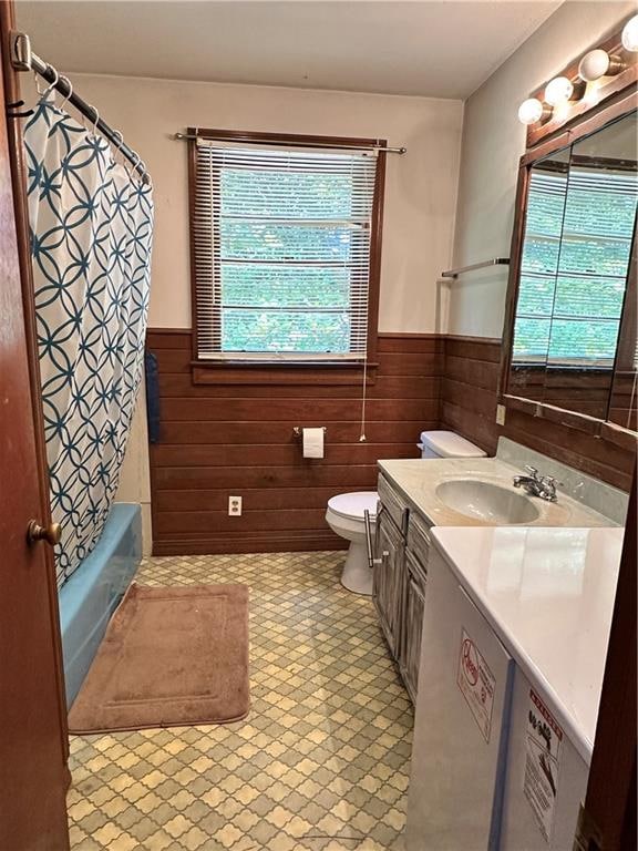 full bathroom featuring a healthy amount of sunlight, oversized vanity, shower / bathtub combination with curtain, and toilet