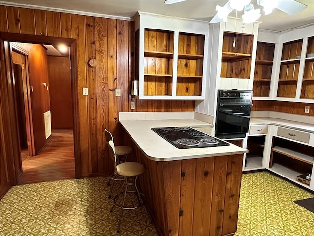 kitchen featuring black appliances, ornamental molding, ceiling fan, and kitchen peninsula