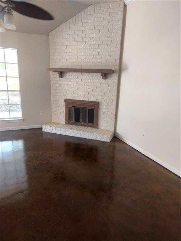 unfurnished living room featuring brick wall, a brick fireplace, vaulted ceiling, and ceiling fan