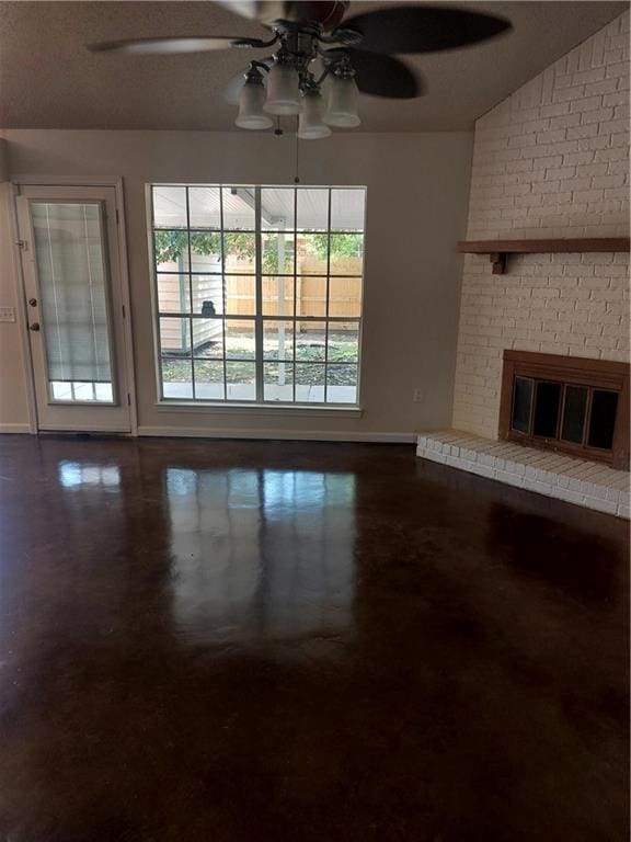 unfurnished living room with brick wall, a healthy amount of sunlight, a fireplace, and ceiling fan