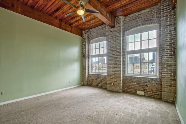 empty room with brick wall, beamed ceiling, wood ceiling, carpet, and ceiling fan