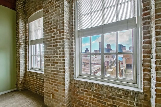 interior space featuring a healthy amount of sunlight and brick wall