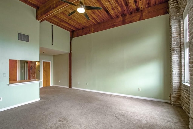 carpeted empty room featuring beamed ceiling, ceiling fan, wood ceiling, and high vaulted ceiling