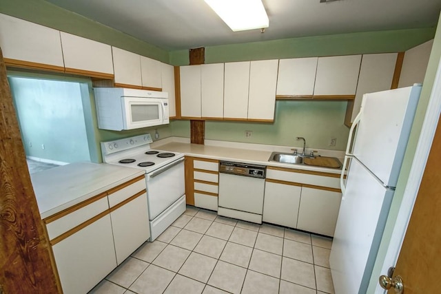 kitchen with sink, white appliances, white cabinetry, and light tile floors