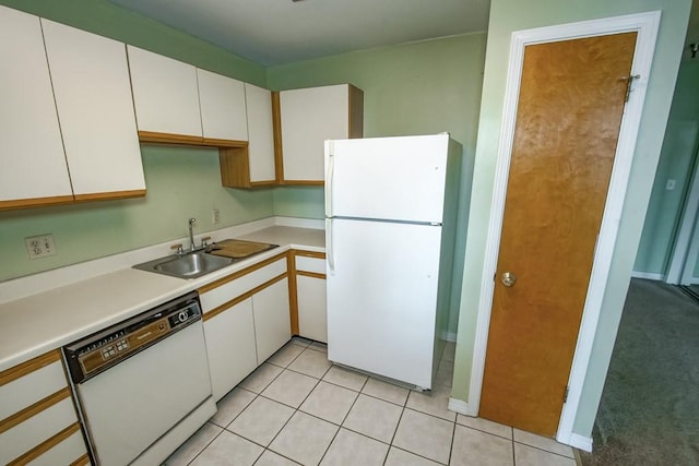 kitchen featuring sink, white appliances, white cabinetry, and light carpet