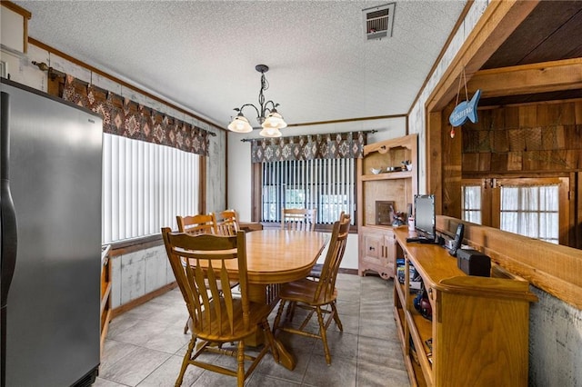 dining room featuring a notable chandelier, ornamental molding, and a wealth of natural light