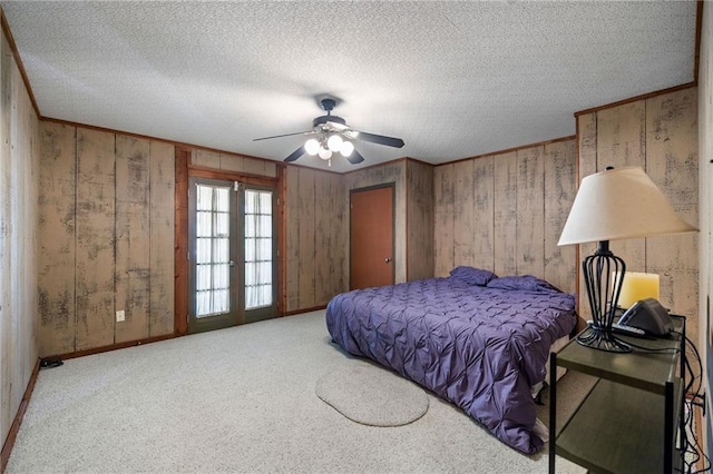 bedroom with ceiling fan, french doors, carpet floors, and a textured ceiling