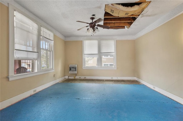 carpeted empty room with baseboards, heating unit, a textured ceiling, and a healthy amount of sunlight