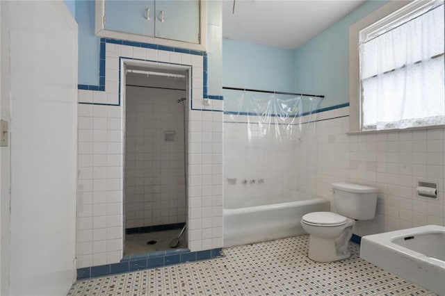 bathroom with tile patterned flooring, tile walls, toilet, and a wainscoted wall