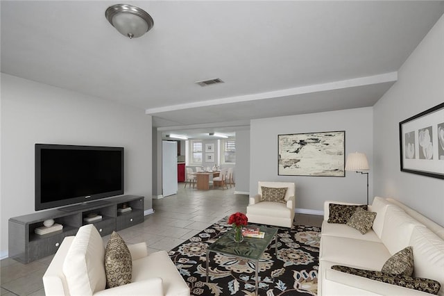 living area featuring light tile patterned floors, baseboards, and visible vents