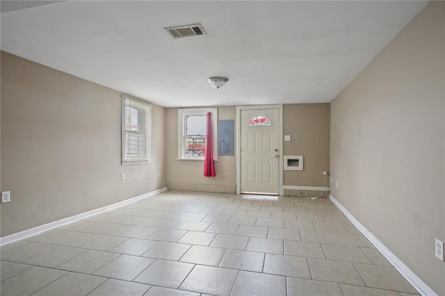 empty room with electric panel, baseboards, and visible vents