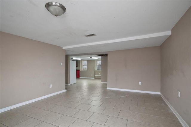 unfurnished room featuring light tile patterned flooring, visible vents, and baseboards