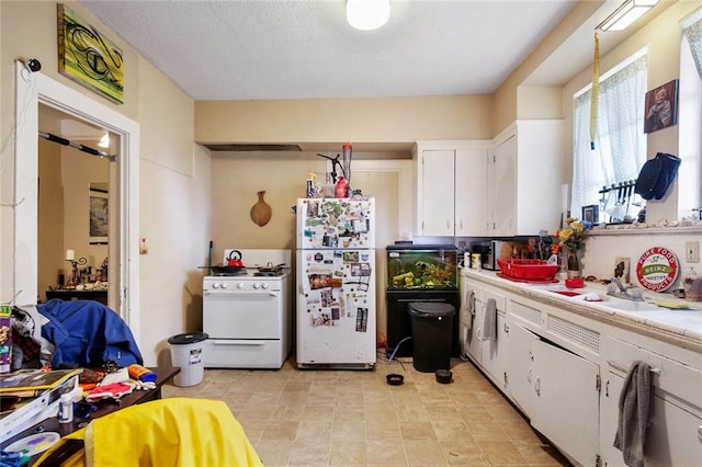 kitchen featuring white cabinets, sink, white appliances, and light tile floors