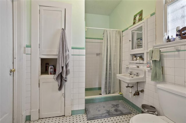 bathroom featuring tile walls, toilet, tile flooring, sink, and walk in shower