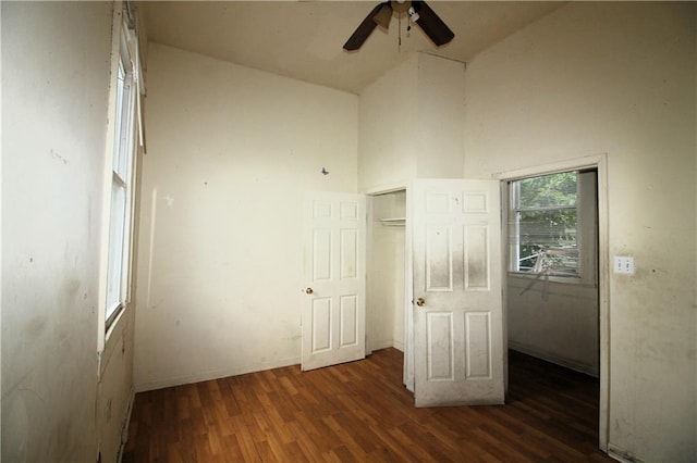 unfurnished bedroom with high vaulted ceiling, dark hardwood / wood-style floors, a closet, and ceiling fan