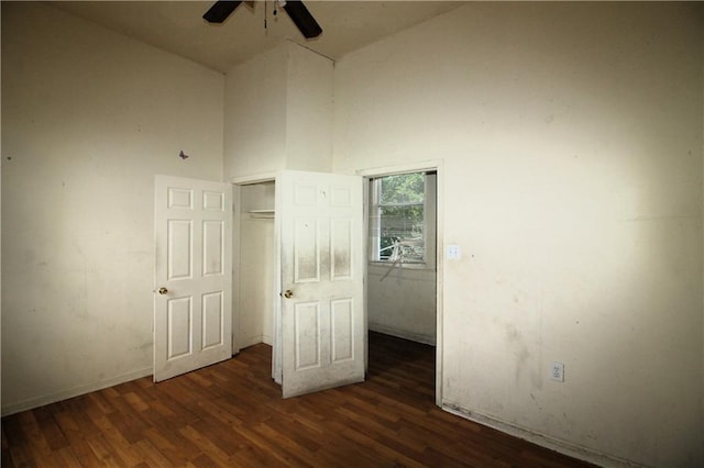 unfurnished bedroom featuring high vaulted ceiling, dark hardwood / wood-style flooring, and ceiling fan