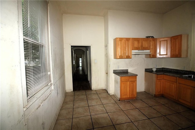 kitchen with tile floors, sink, and a high ceiling