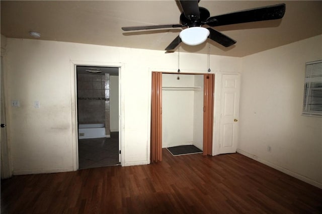 unfurnished bedroom with ceiling fan, a closet, ensuite bath, and dark wood-type flooring