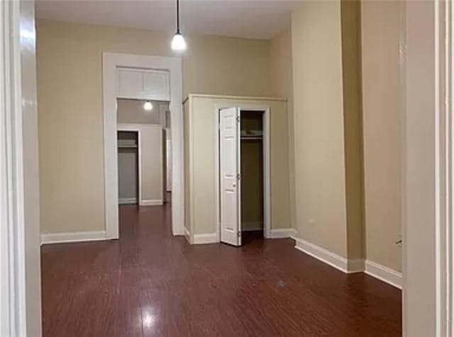 unfurnished bedroom with dark wood-type flooring