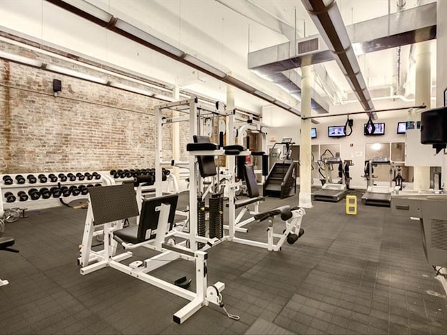 exercise room featuring brick wall