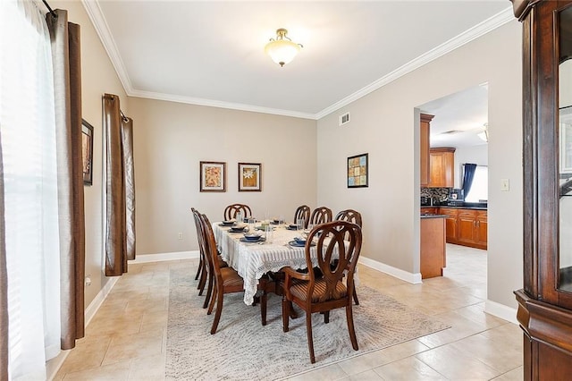 dining area featuring crown molding and light tile patterned floors