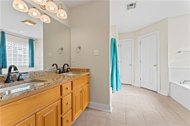 bathroom featuring double vanity, visible vents, a sink, and tile patterned floors