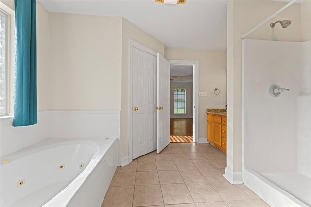 bathroom with a whirlpool tub, a shower, vanity, and tile patterned floors