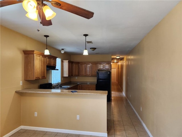 kitchen with ceiling fan, kitchen peninsula, pendant lighting, black fridge, and light tile floors