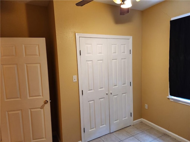 unfurnished bedroom with a closet, ceiling fan, and light tile floors