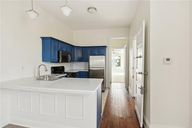 kitchen featuring sink, appliances with stainless steel finishes, blue cabinets, decorative light fixtures, and kitchen peninsula