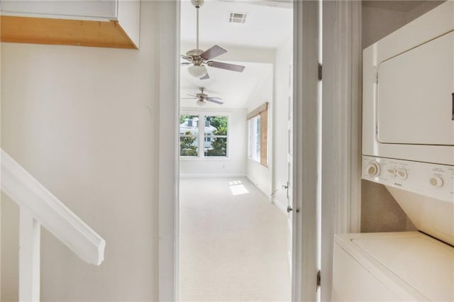 hall featuring stacked washer and dryer