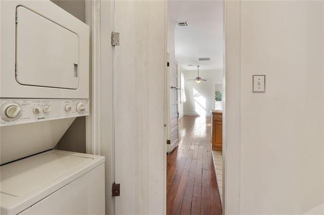 washroom featuring stacked washer and dryer, dark hardwood / wood-style floors, and ceiling fan