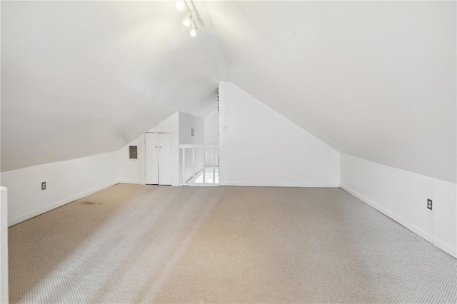 additional living space with carpet floors and vaulted ceiling