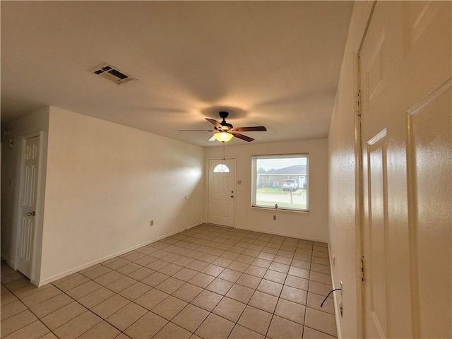 tiled spare room featuring ceiling fan