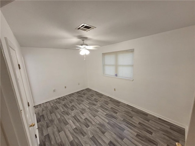 spare room featuring ceiling fan and dark wood-type flooring