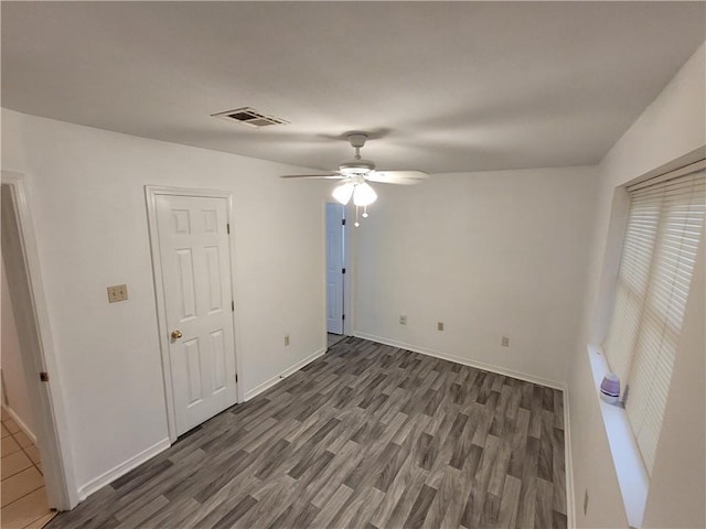 empty room featuring ceiling fan and dark wood-type flooring