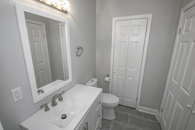 bathroom featuring toilet, tile patterned floors, a closet, and vanity