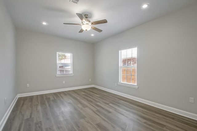 empty room featuring recessed lighting, wood finished floors, and baseboards