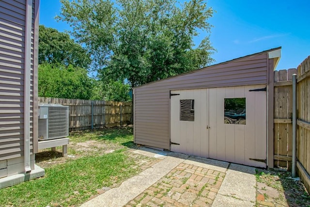 view of shed with a fenced backyard and central air condition unit