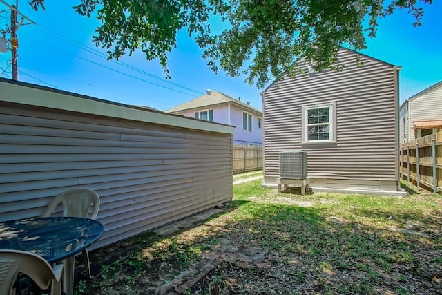 exterior space with central air condition unit and fence