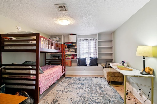 bedroom featuring a textured ceiling and wood-type flooring