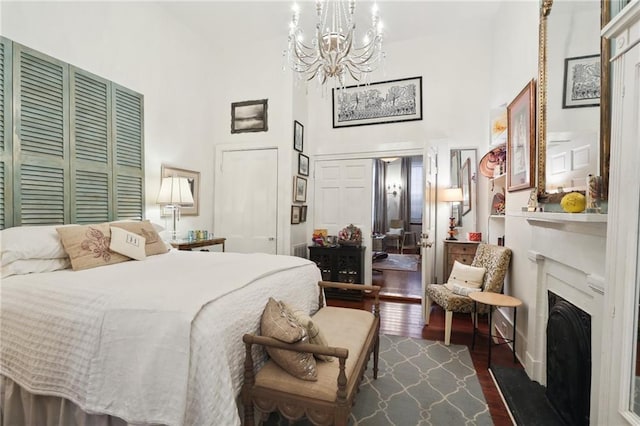 bedroom featuring a high ceiling, a closet, a chandelier, and dark hardwood / wood-style floors