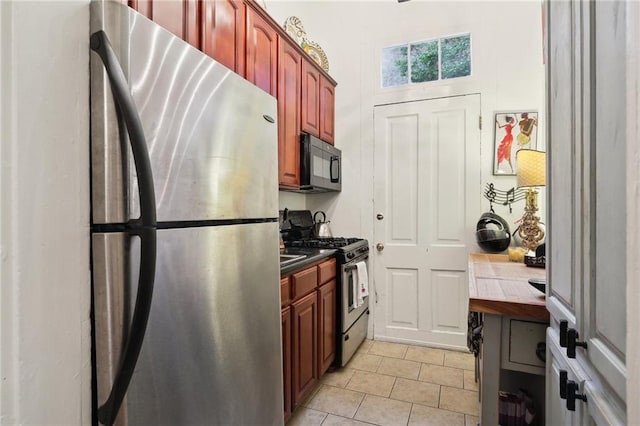 kitchen with tile counters, stainless steel appliances, and light tile floors