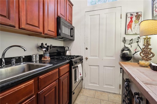 kitchen featuring sink, stainless steel gas range, and light tile floors