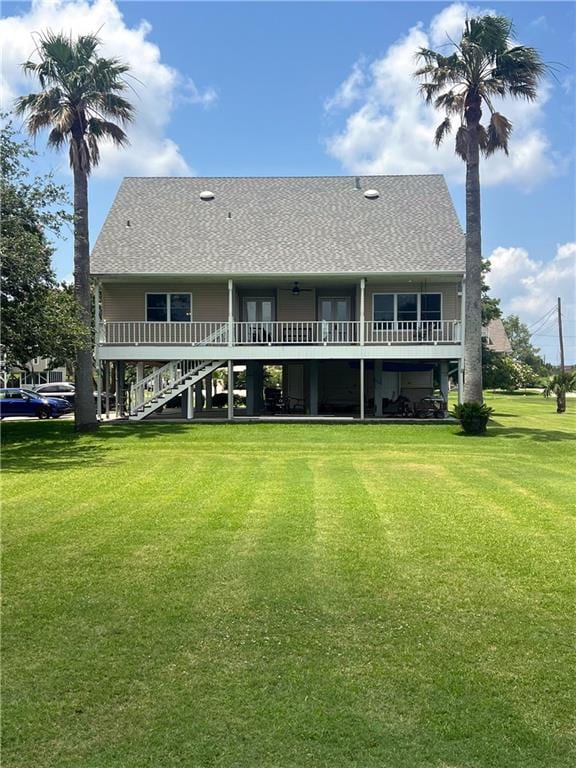 rear view of property featuring a lawn