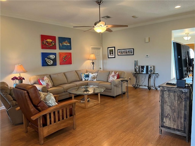 living room featuring wood-type flooring, ceiling fan, and crown molding