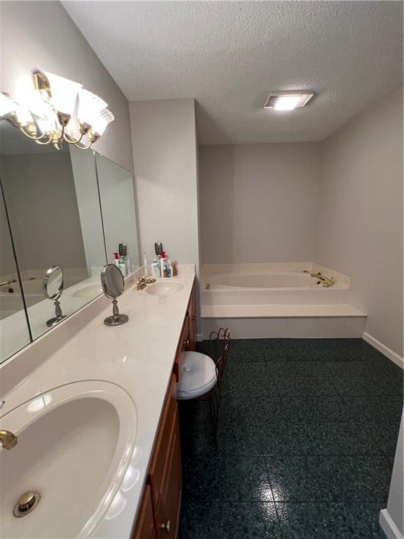 bathroom with tile flooring, a textured ceiling, a tub, an inviting chandelier, and double sink vanity