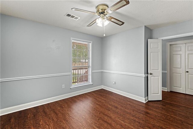 unfurnished room featuring wood finished floors, visible vents, a ceiling fan, baseboards, and a textured ceiling