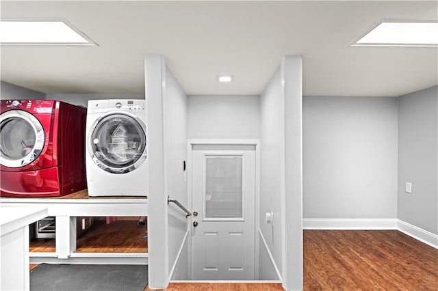 clothes washing area with independent washer and dryer and wood-type flooring