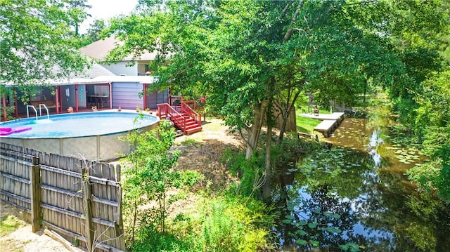 outdoor pool with fence and a deck